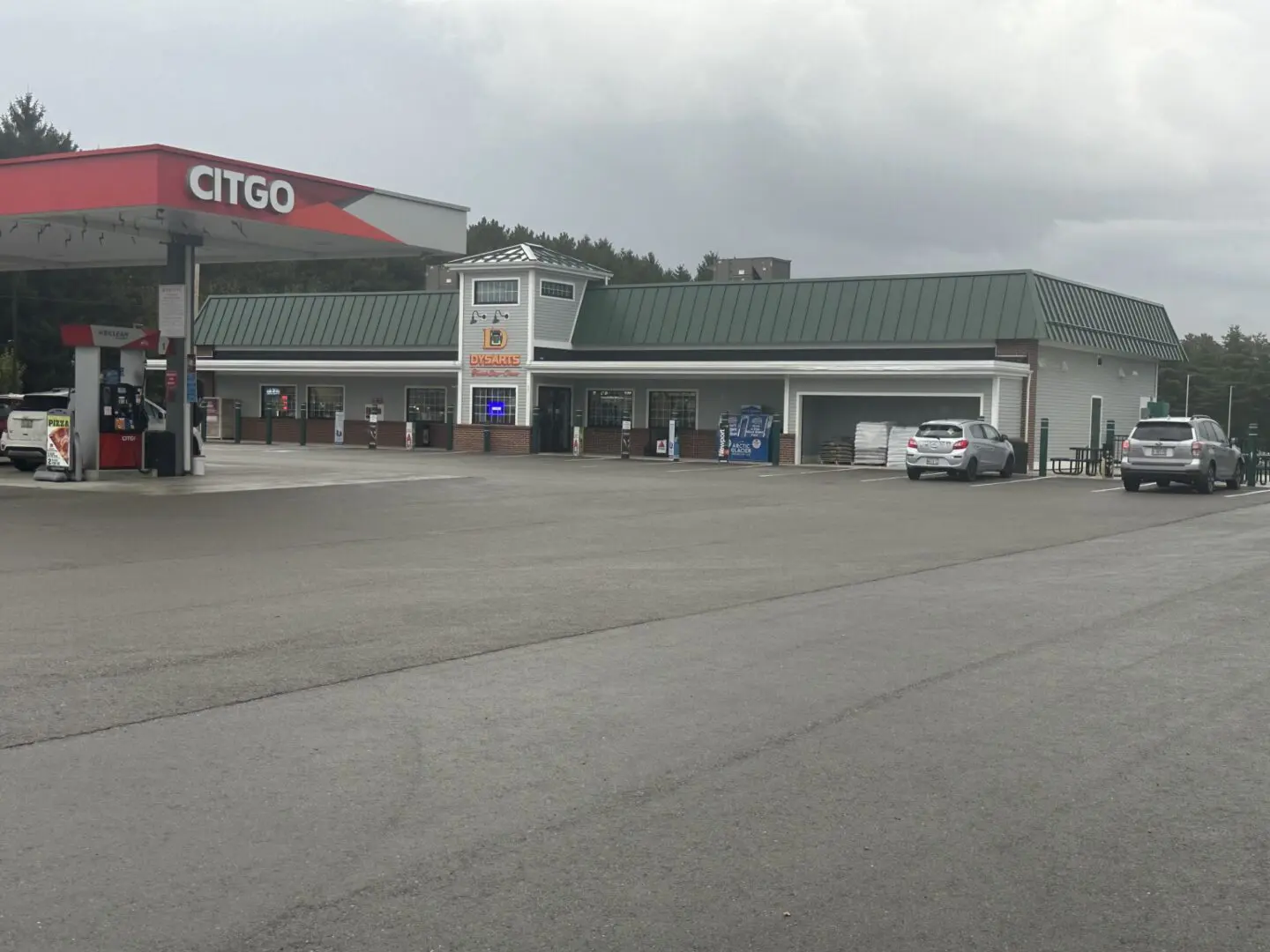 A large gas station with cars parked in front of it.